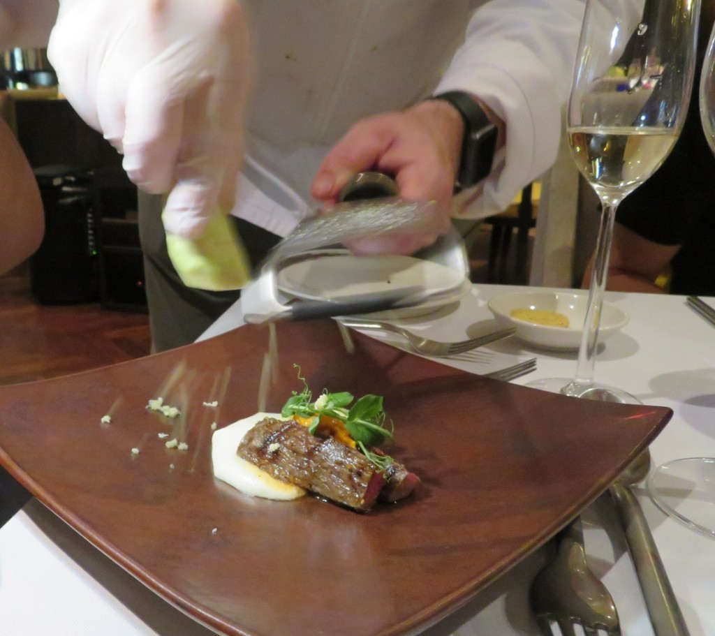 The chef shaving fresh wasabi over the  Wagyu Petit Tender Oer the Coals, Sea Urchin, Wasabi, Paris Mash