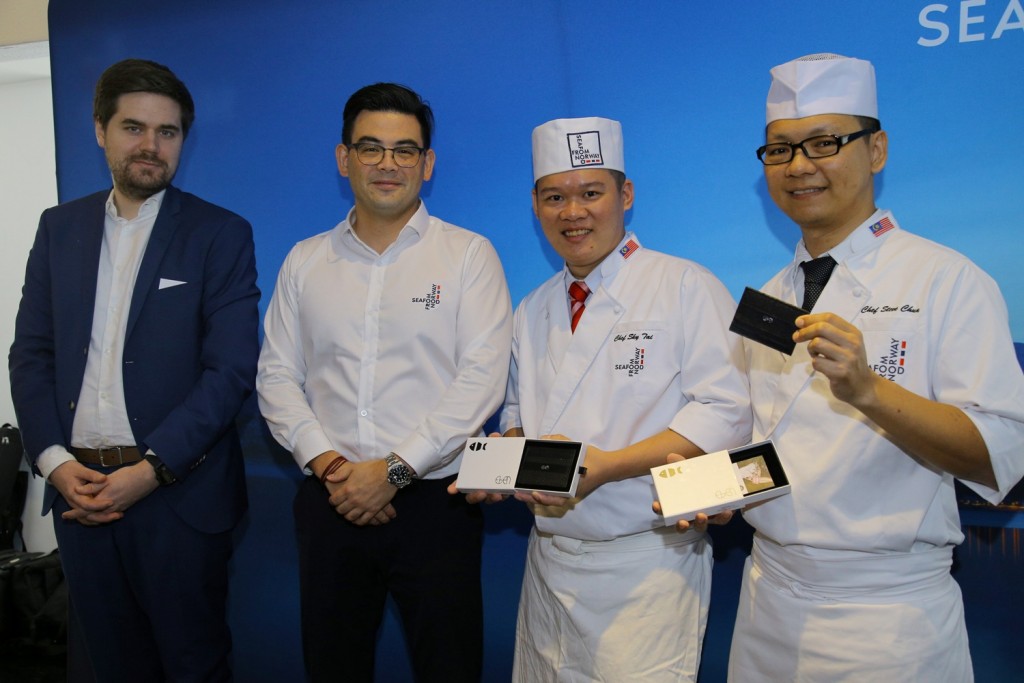 The two chefs were presented with tokens of appreciation -- a salmon skin card holder -- by Jon Erik Steenslid. Looking on is First Secretary of the Royal Norwegian Embassy Erlend Sannes Hadland